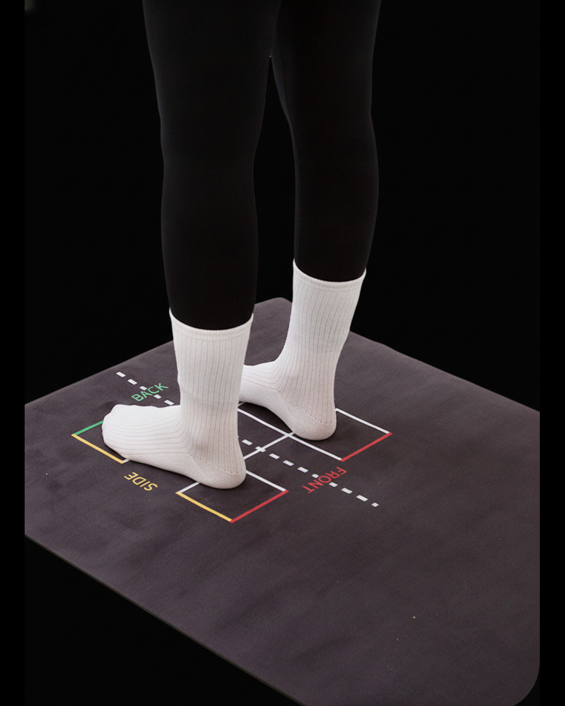 Feet positioned on the MOTI Physio alignment mat, showing the front, side, and back scan markers